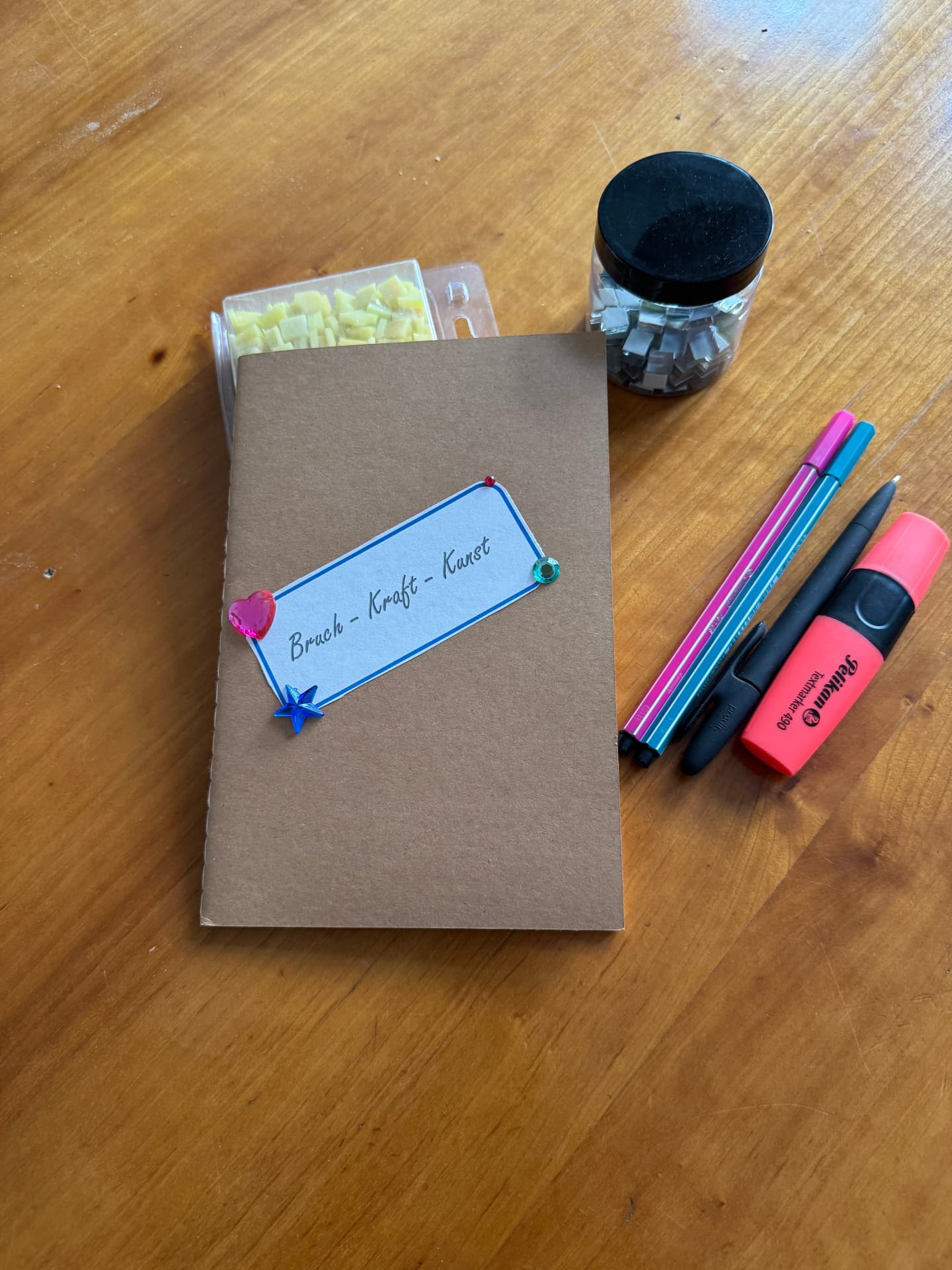 Notizbuch 'Bruch-Kraft-Kunst' mit Mosaiksteinen und Stiften – Vorbereitung eines Resilienz-Workshops