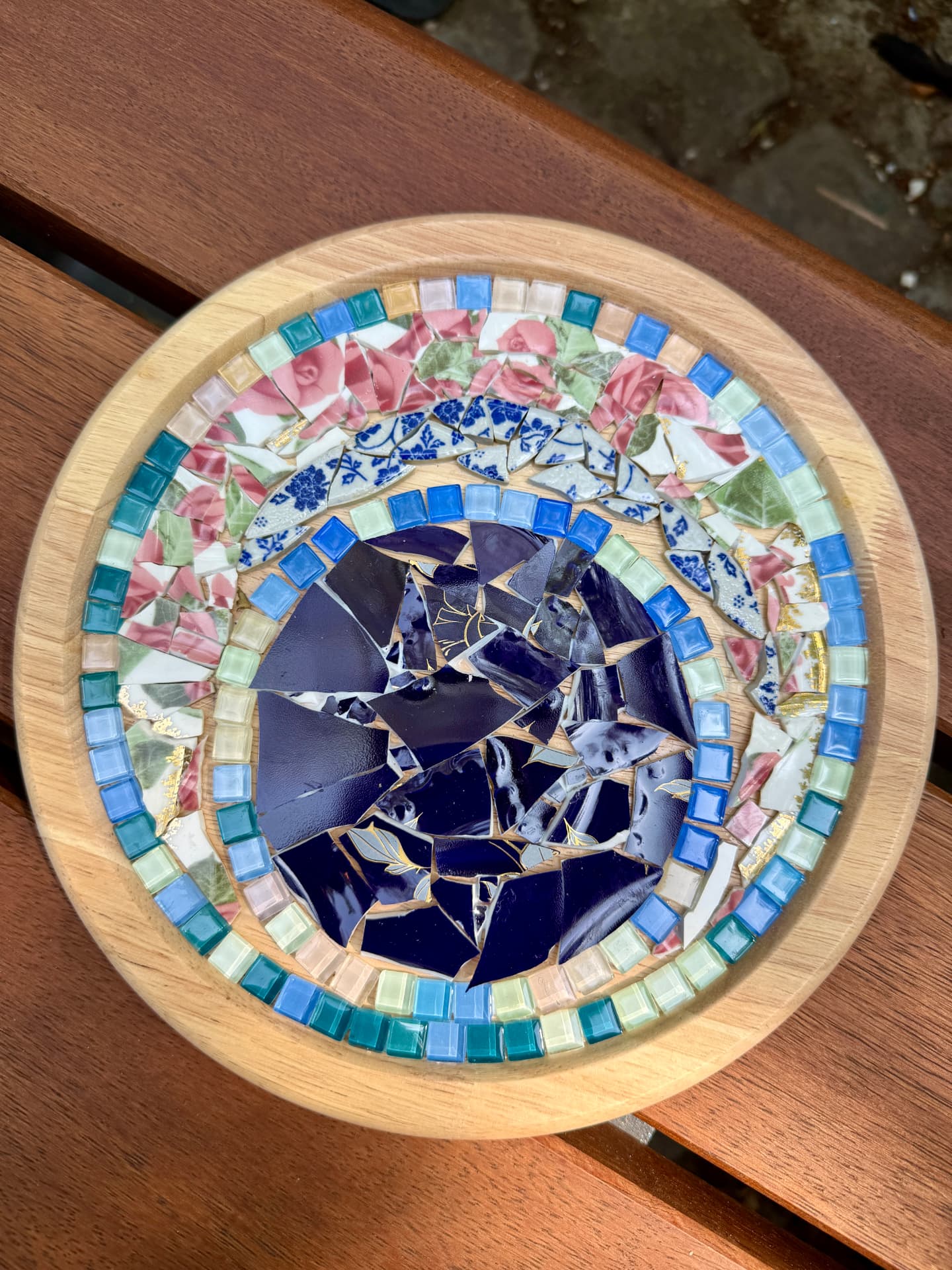 Runde Mosaikschale aus Holz mit blauen und rosé Scherben